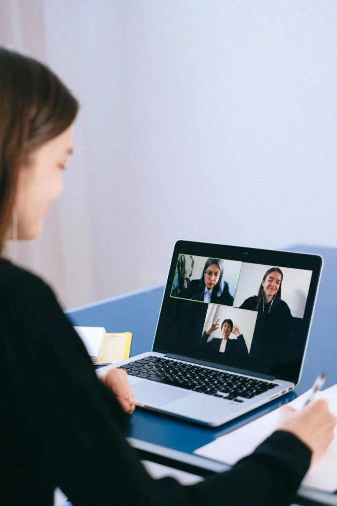 Kvinne i videomøte med kolleger på laptop