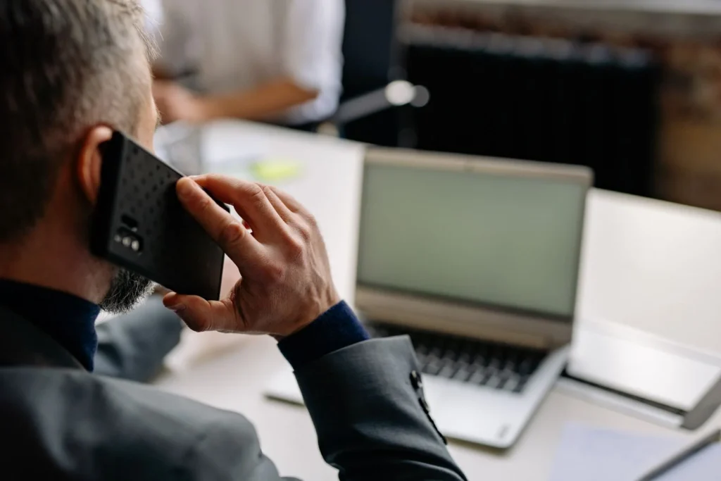 Medarbeider med telefon og PC samtidig