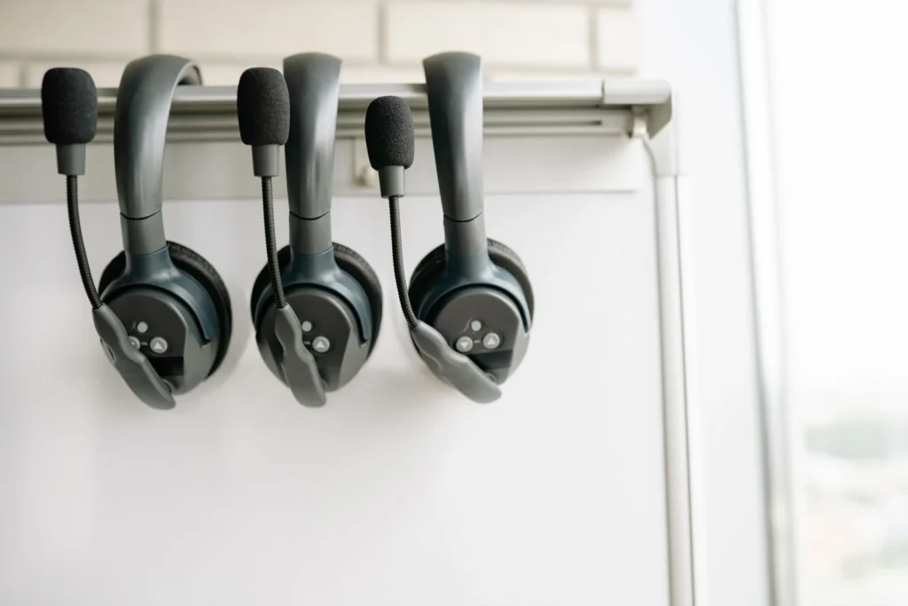 Tre headset hengt opp på tavle